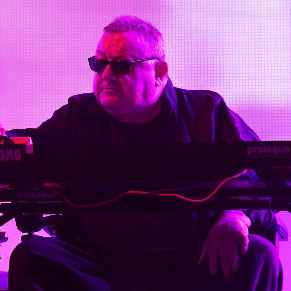 Dave Ball spielt Keyboard unter violettem Bühnenlicht.