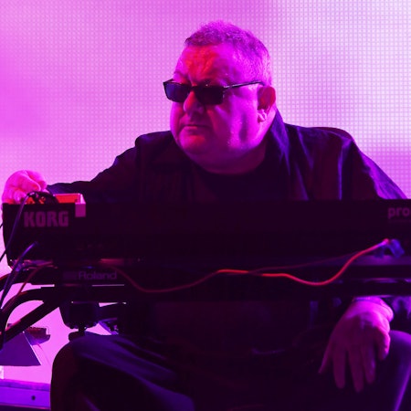 Dave Ball spielt Keyboard unter violettem Bühnenlicht.