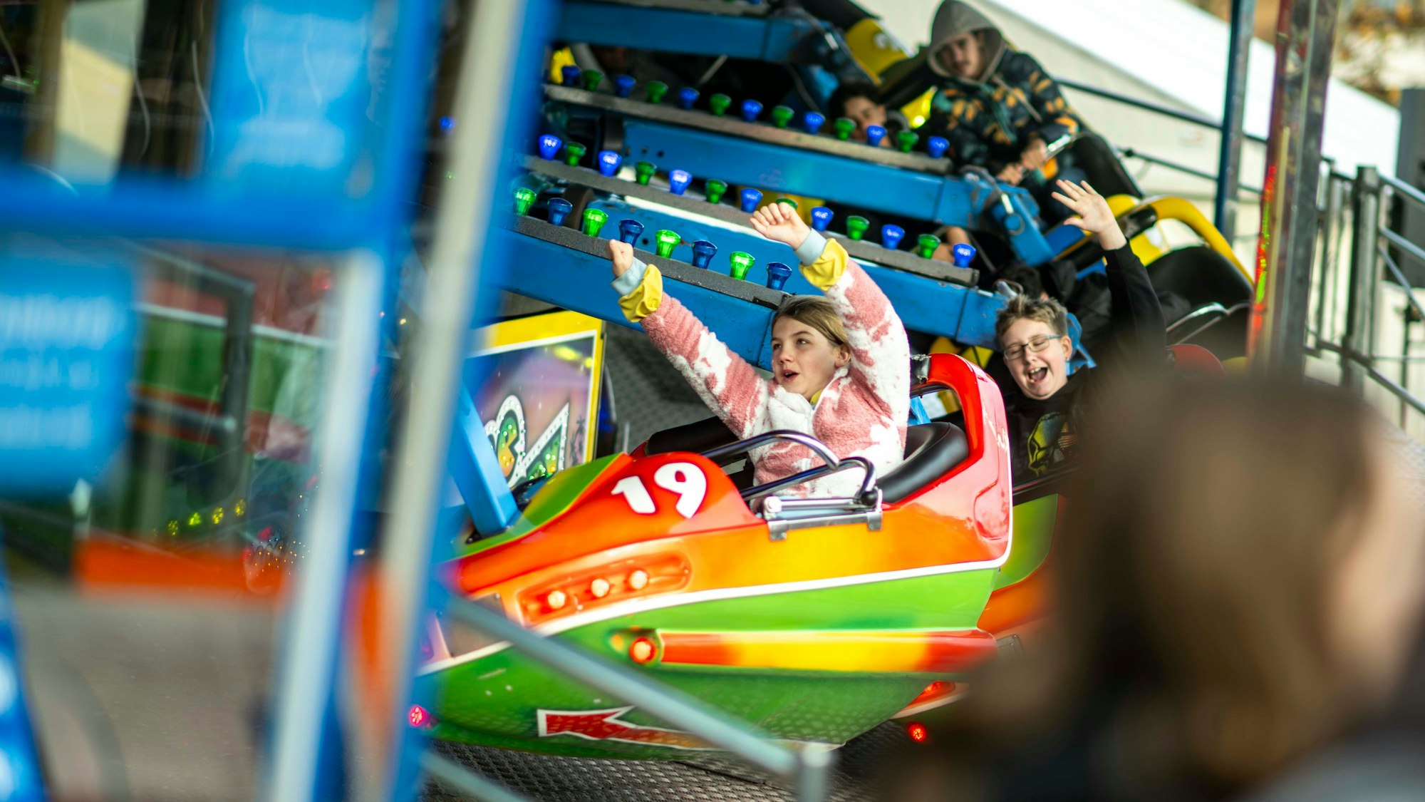 Das Bild zeigt ein Fahrgeschäft auf dem Simon-Juda-Markt. Zwei Jugendliche reißen die Arme in die Luft.