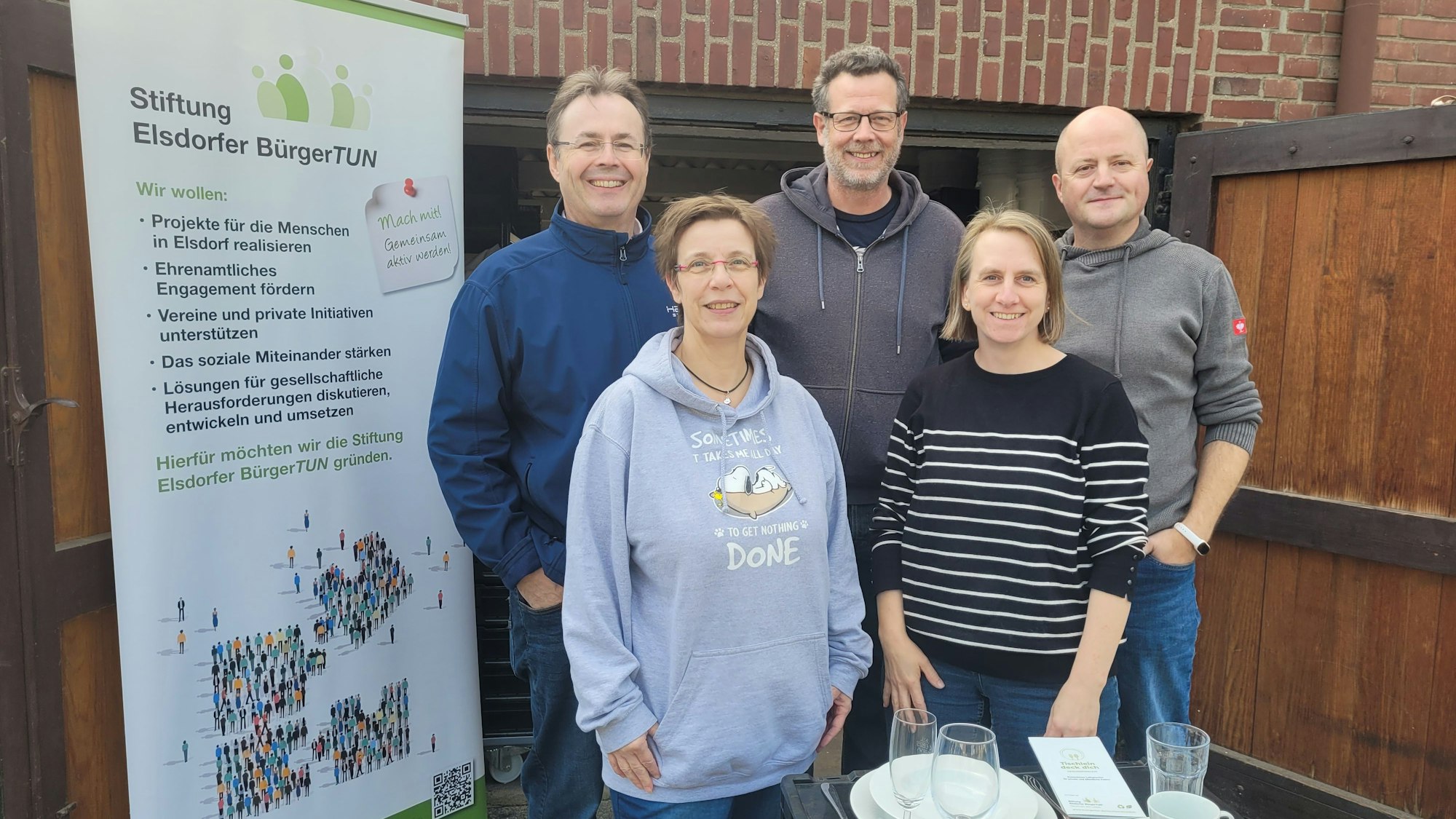 Die Akteure stehen neben einem Banner mit der Aufschrift „Stiftung Elsdorfer BürgerTUN“