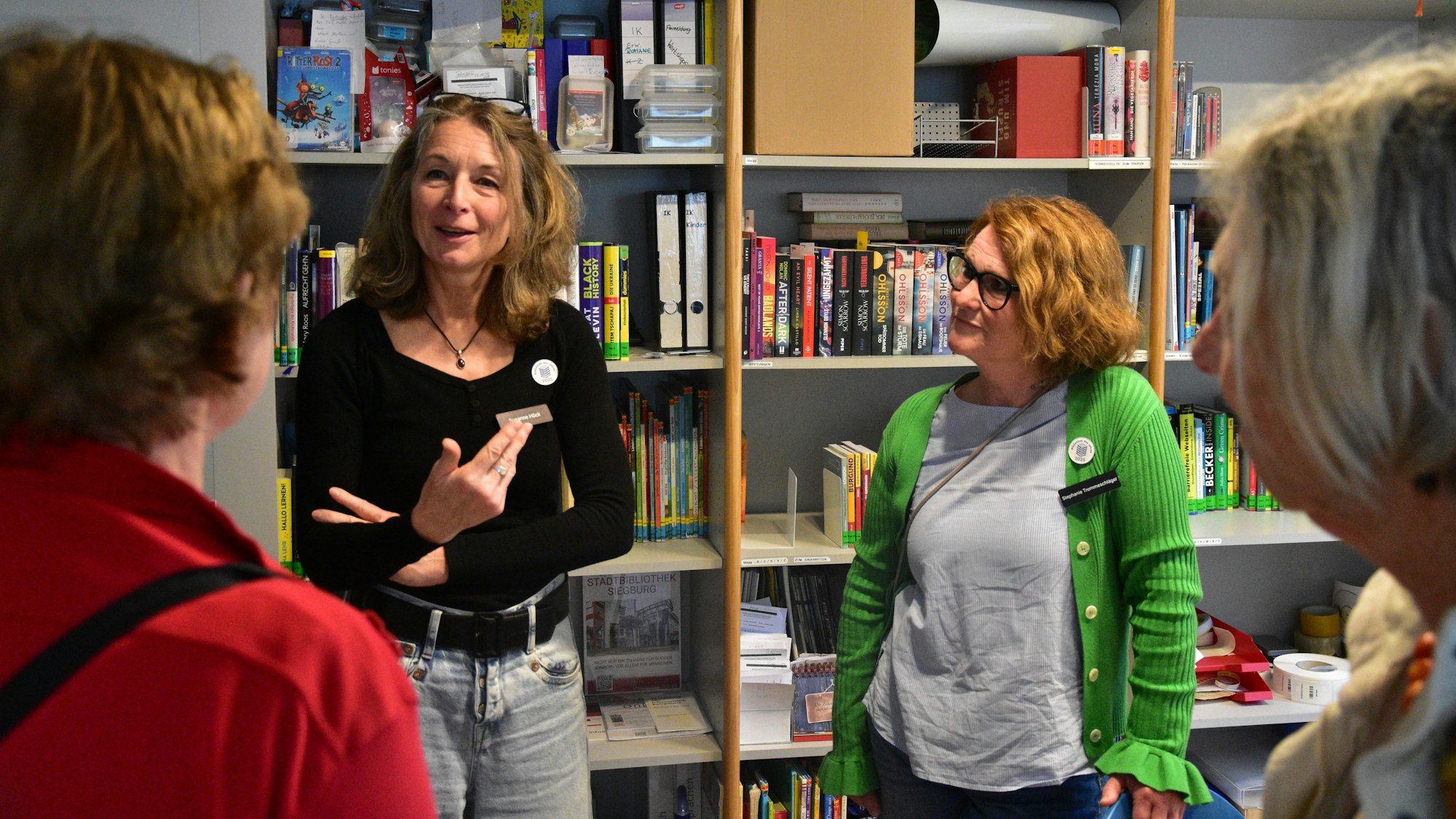 Zwei Frauen stehen vor einem Regal in einem Büro.