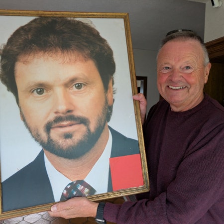 Hans Schmitz hält das Foto aus seinem Wahlkampf 1994 in der Hand, das Freunde für ihn mit einem goldenen Rahmen versehen haben.