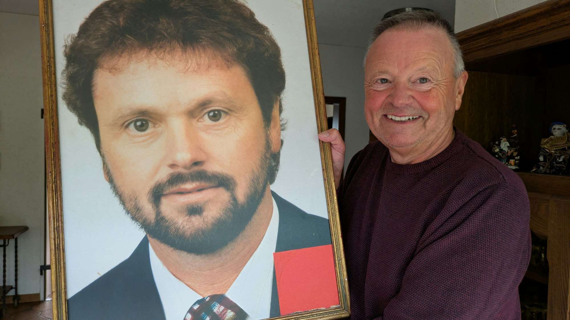 Hans Schmitz hält das Foto aus seinem Wahlkampf 1994 in der Hand, das Freunde für ihn mit einem goldenen Rahmen versehen haben.