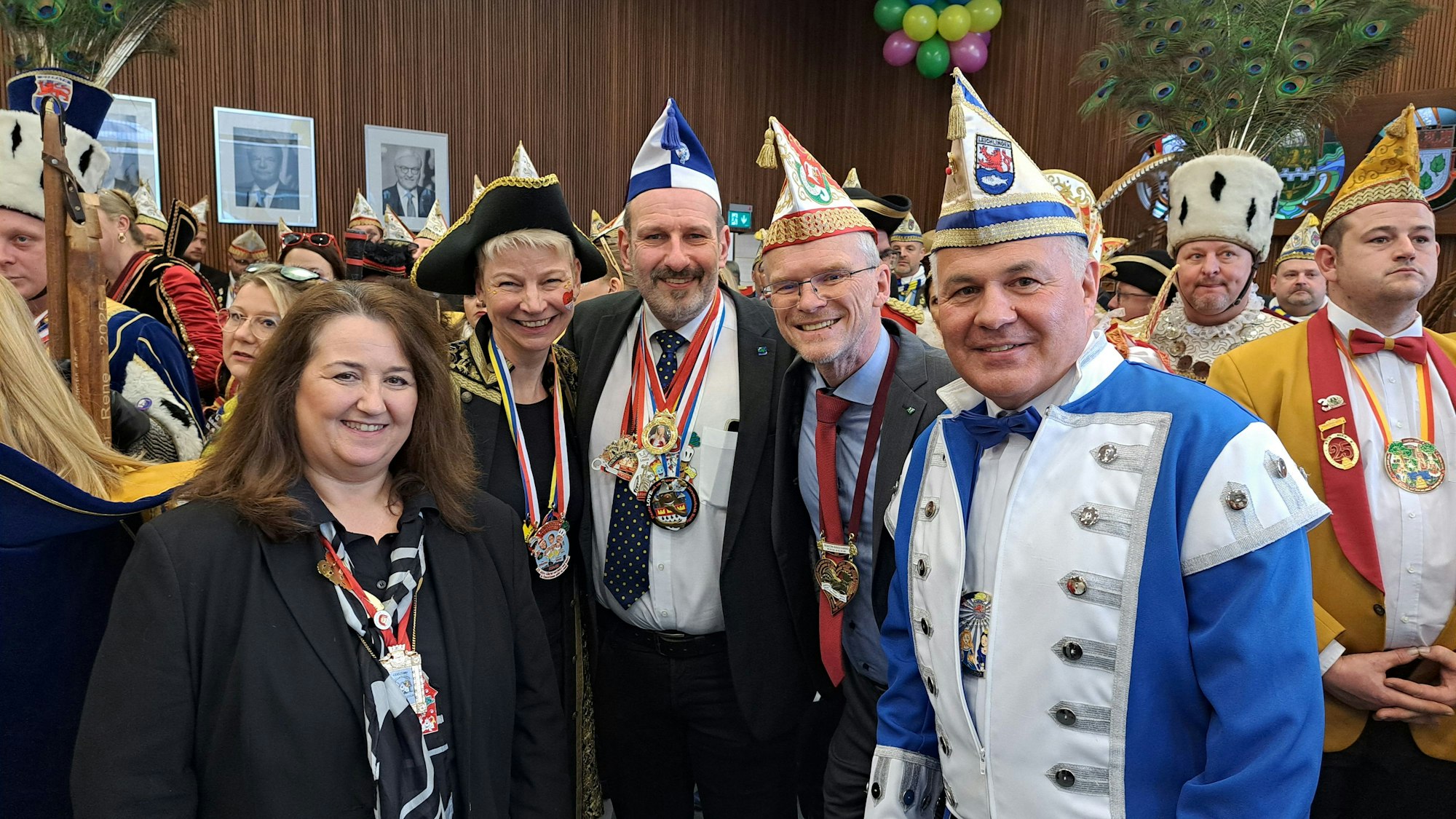 Arm in Arm stehen fünf Bürgermeister inmitten von Karnevalisten.