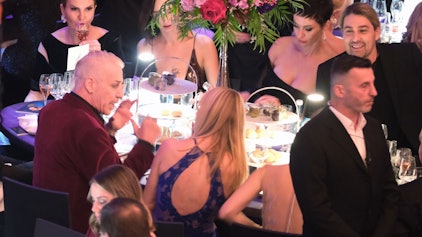 Das Bild zeigt Till Lindemann (l), Sänger der Band Rammstein, beim Leipziger Opernball an einem Tisch, rechts ist Star-Geiger David Garrett zu sehen. Foto: Sebastian Willnow/dpa