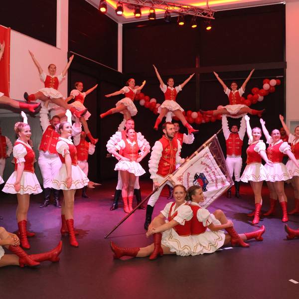 Im sitzen und im stehen, präsentiert sich eine Tanzgruppe auf der Bühne.