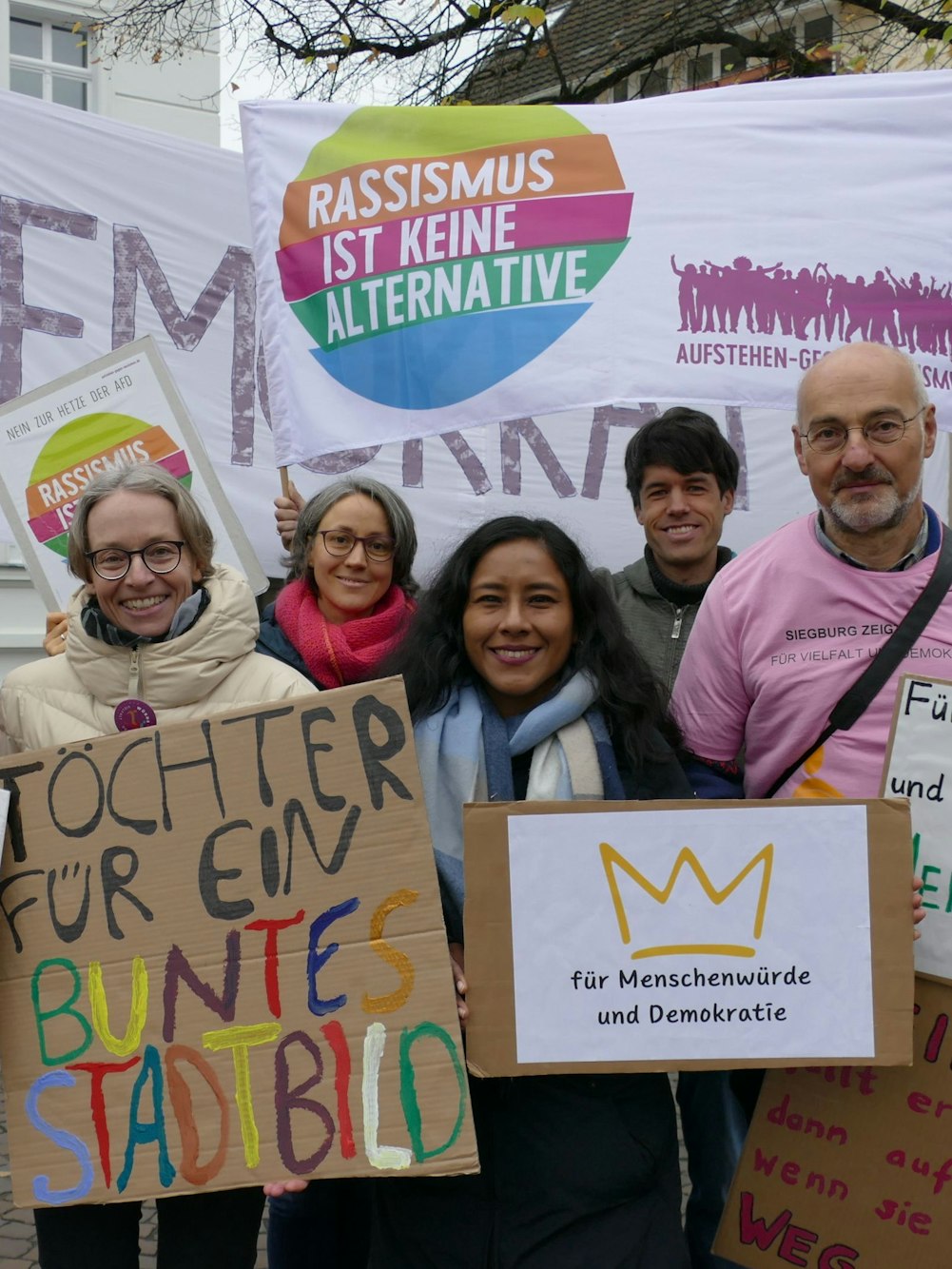 Männer und Frauen mit Protestplakaten.