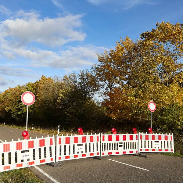 Auf der Landstraße stehen rot-weiße Absperrungen.