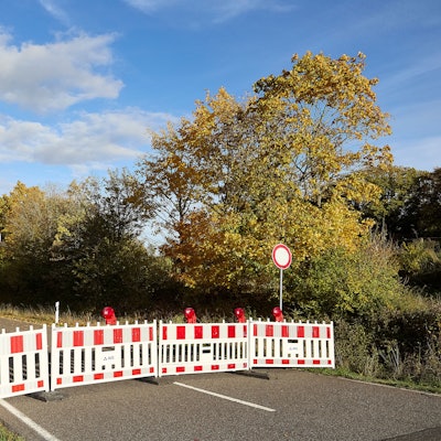 Auf der Landstraße stehen rot-weiße Absperrungen.