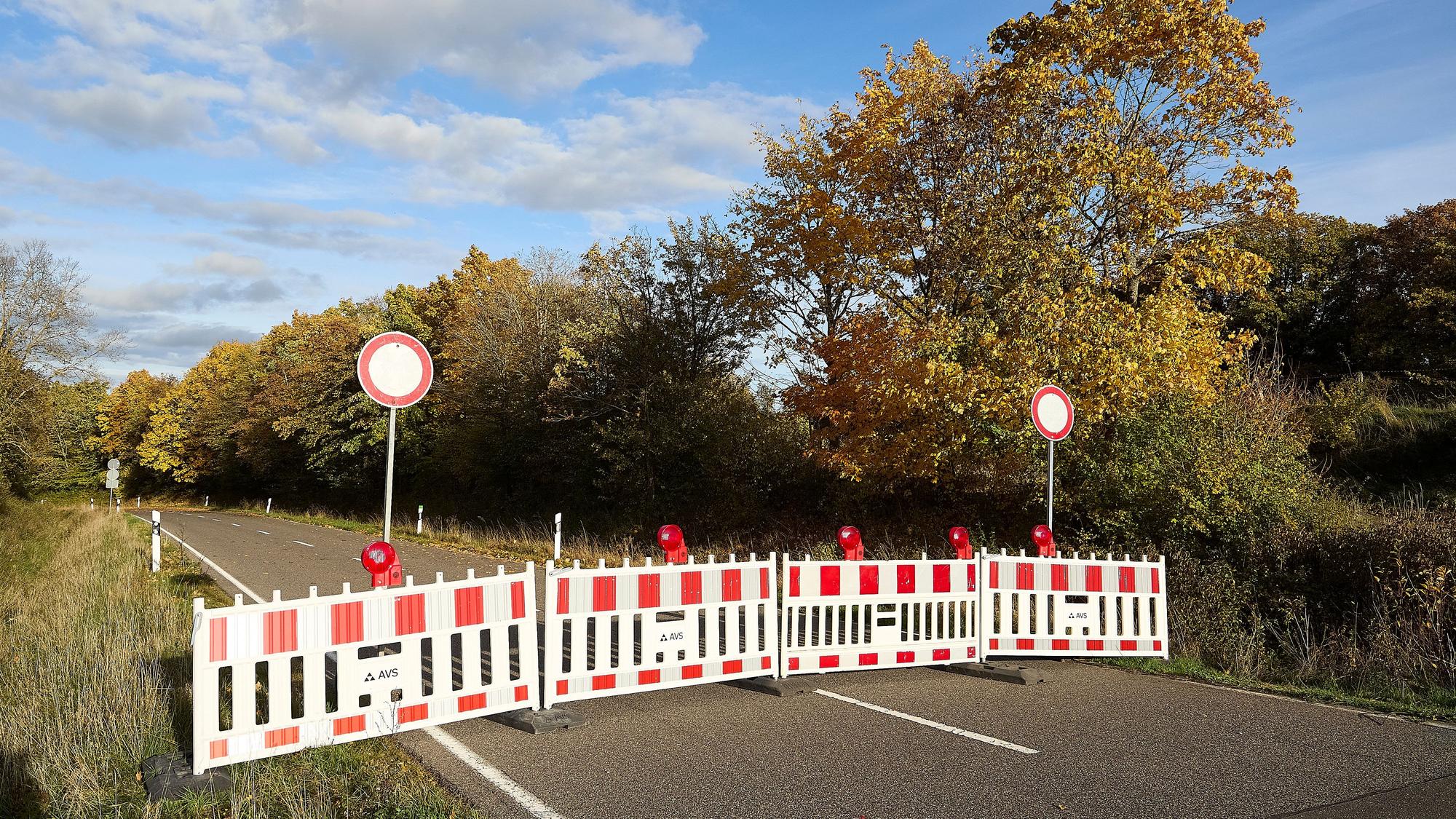 Auf der Landstraße stehen rot-weiße Absperrungen.
