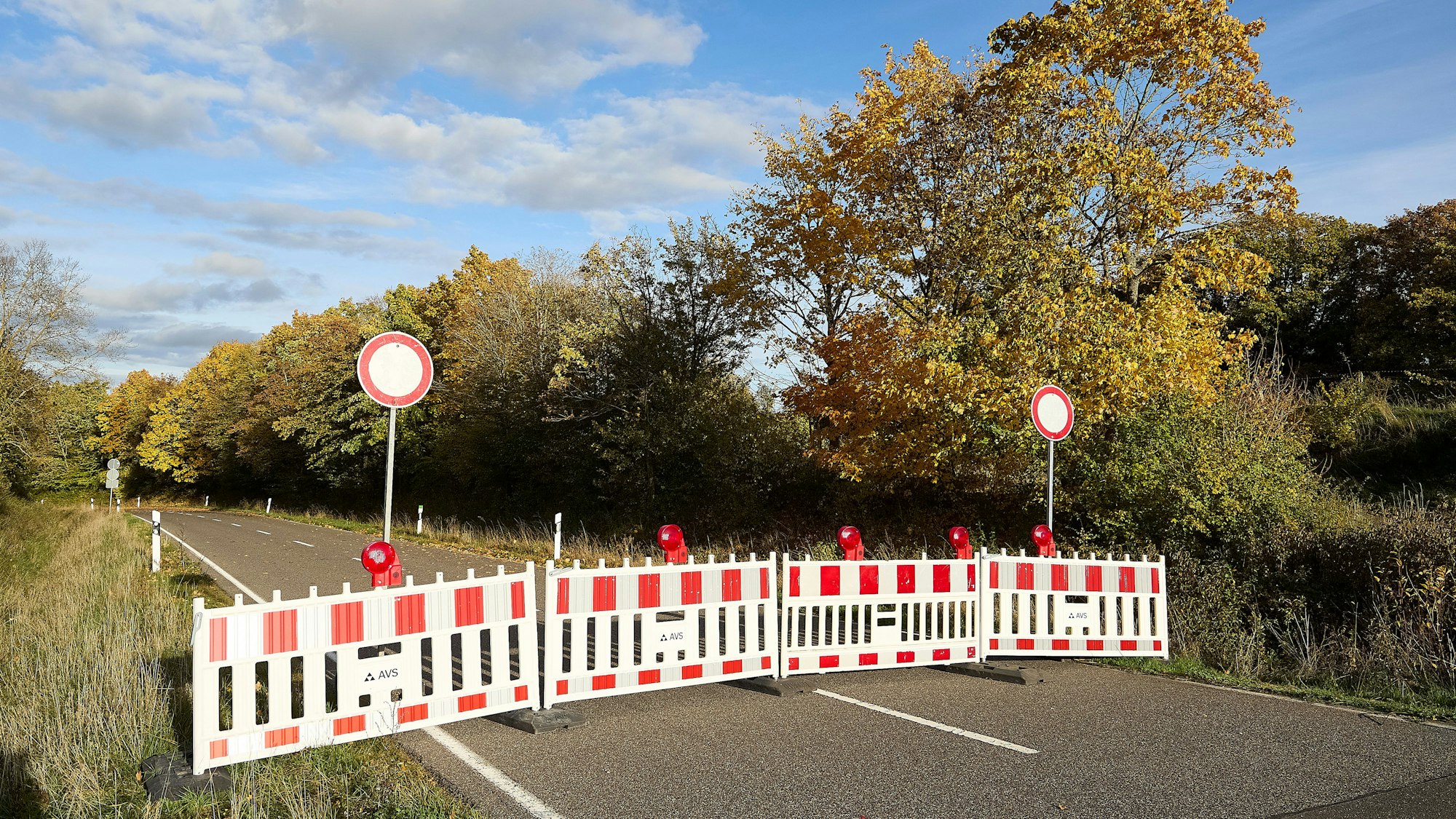 Auf der Landstraße stehen rot-weiße Absperrungen.