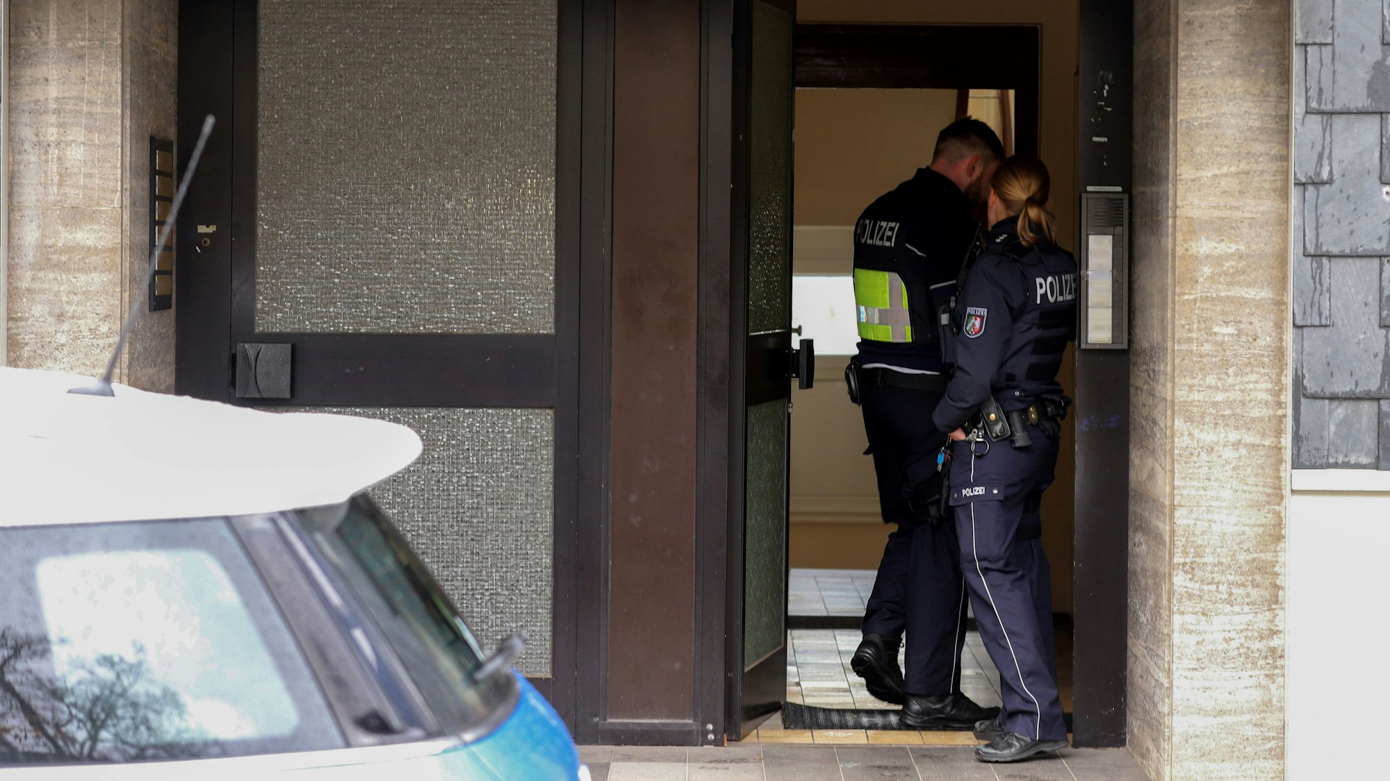 Remscheid: Polizisten stehen am Montag (27. Oktober) im Hauseingang eines Gebäudes, das im Zusammenhang mit einer Razzia gegen organisierte Kriminalität steht.