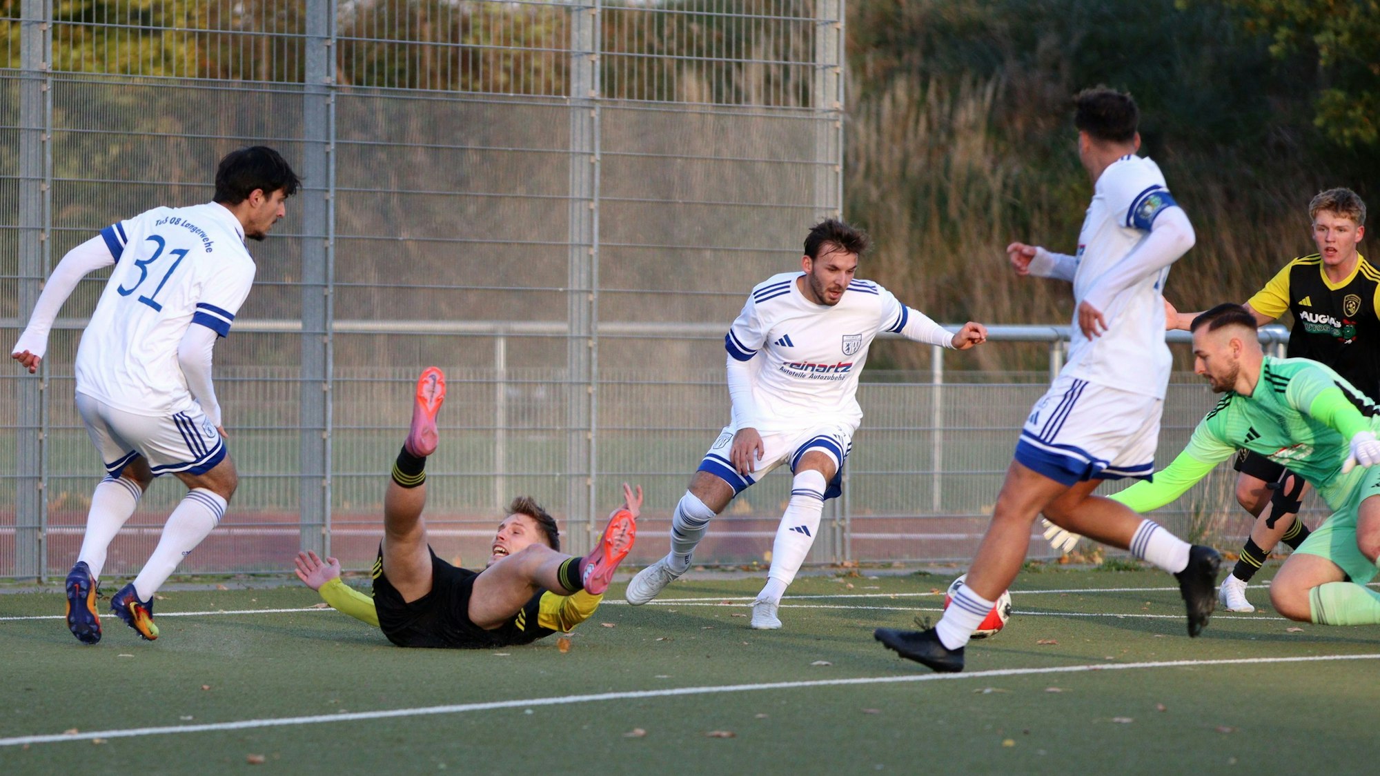 Erftstadt-Lechenichs Spieler Jan-Philipp Schmitz liegt auf dem Rücken und beschwert sich mit ausgestreckten Armen. Der Ball liegt zwischen Torwart und einem Verteidiger von Langerwehe.