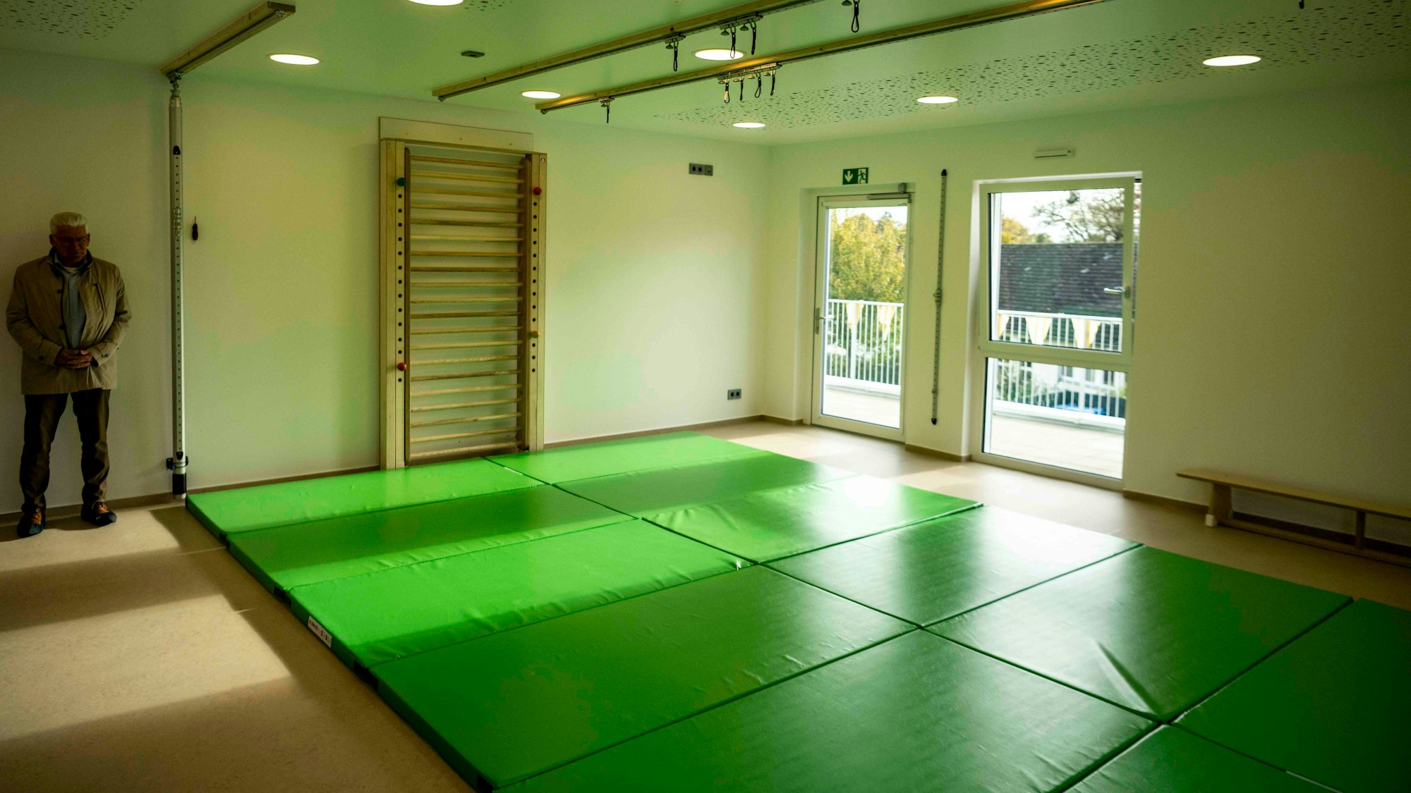 Das Bild zeigt den Raum, in dem Kinder an ihrer Motorik arbeiten können. Ausgelegt ist er mit grünen Matten.