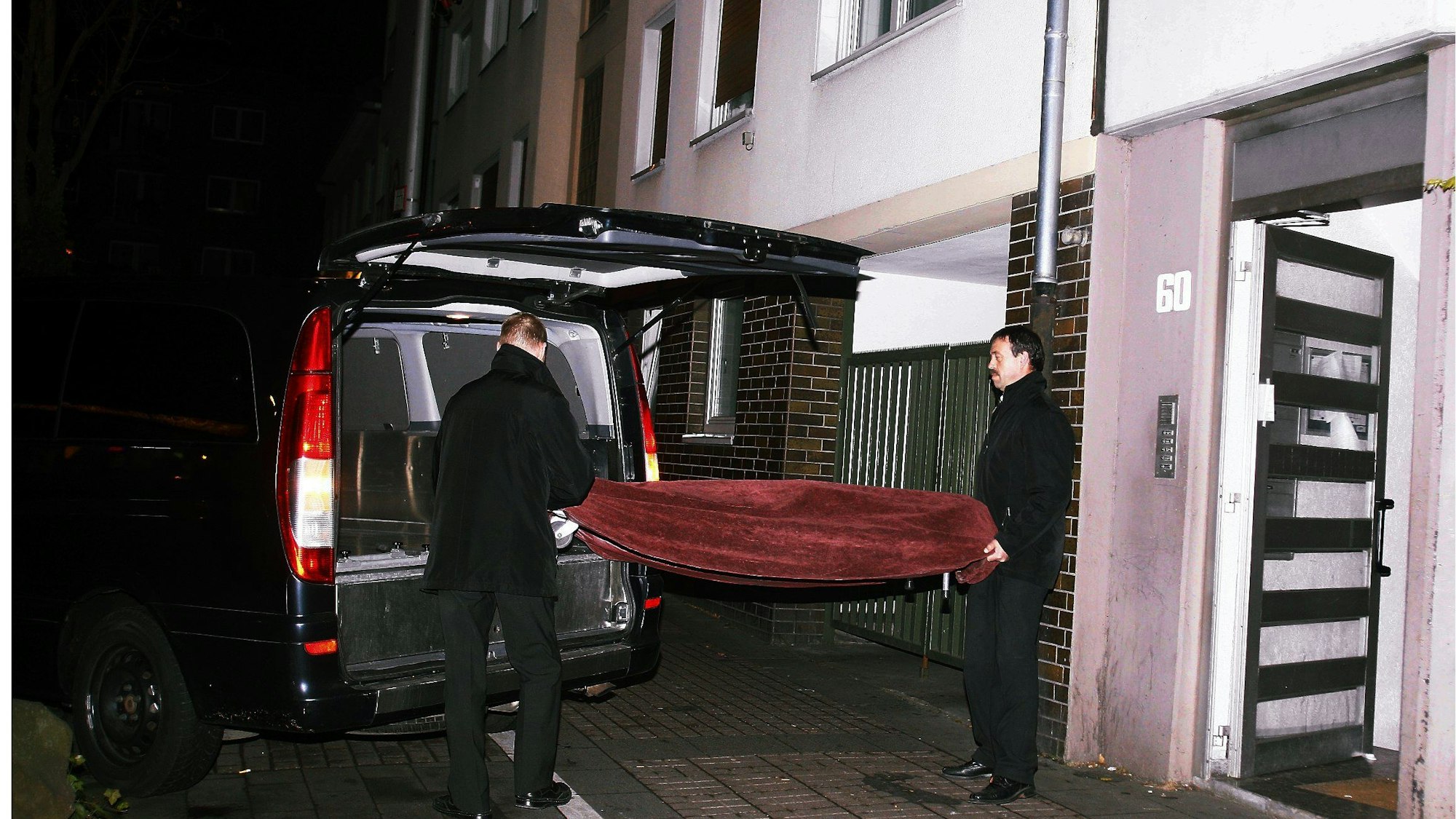 Das Bild zeigt die Bestatter, die 2011 die Leiche in Vingst abtransportierten. (Archivbild)