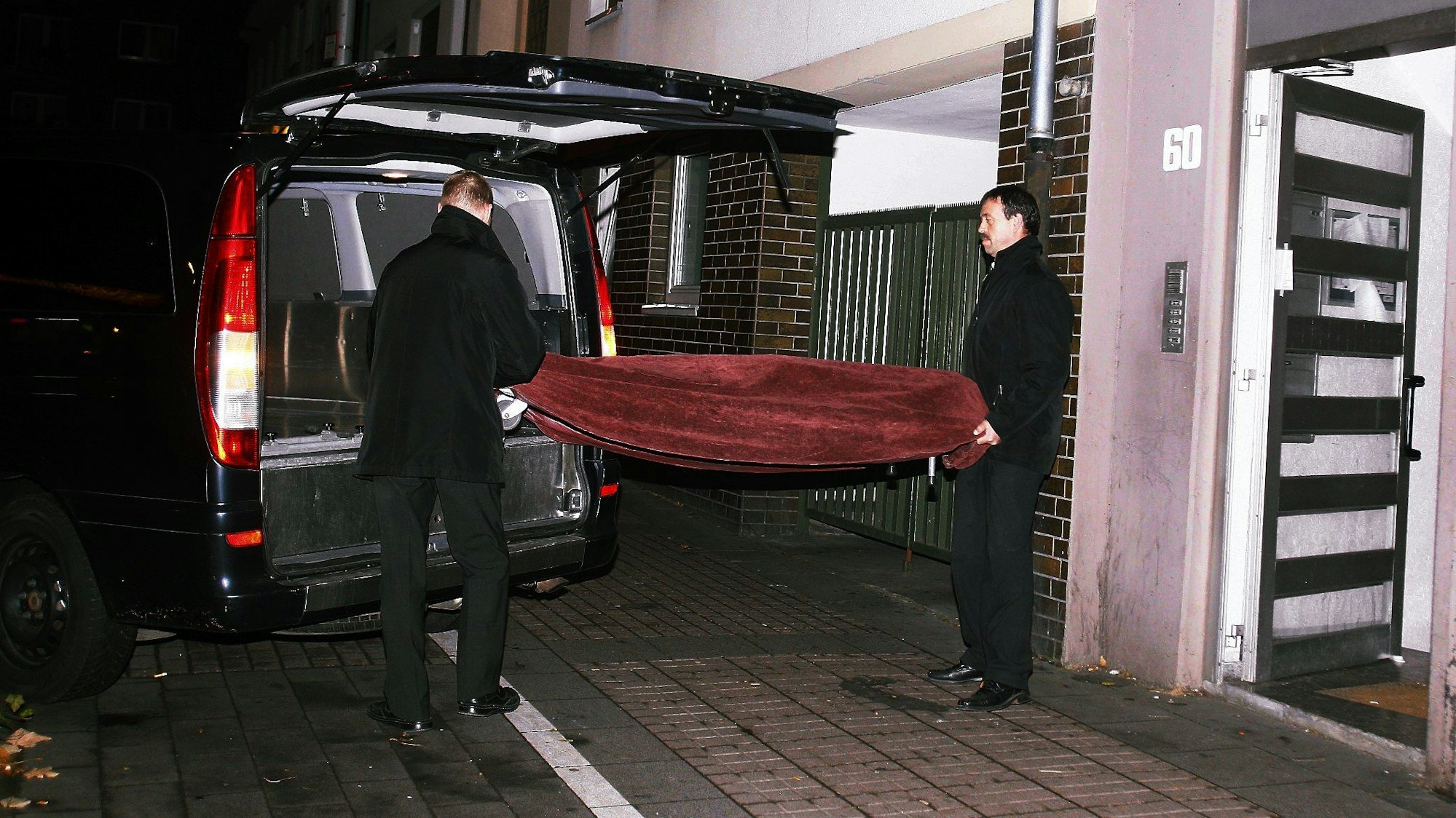 November 2011: Bestatter transportieren den Leichnam aus der Wohnung ab.