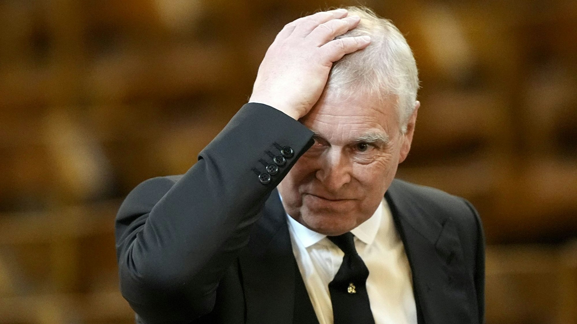 Prinz Andrew streicht sich über den Kopf.