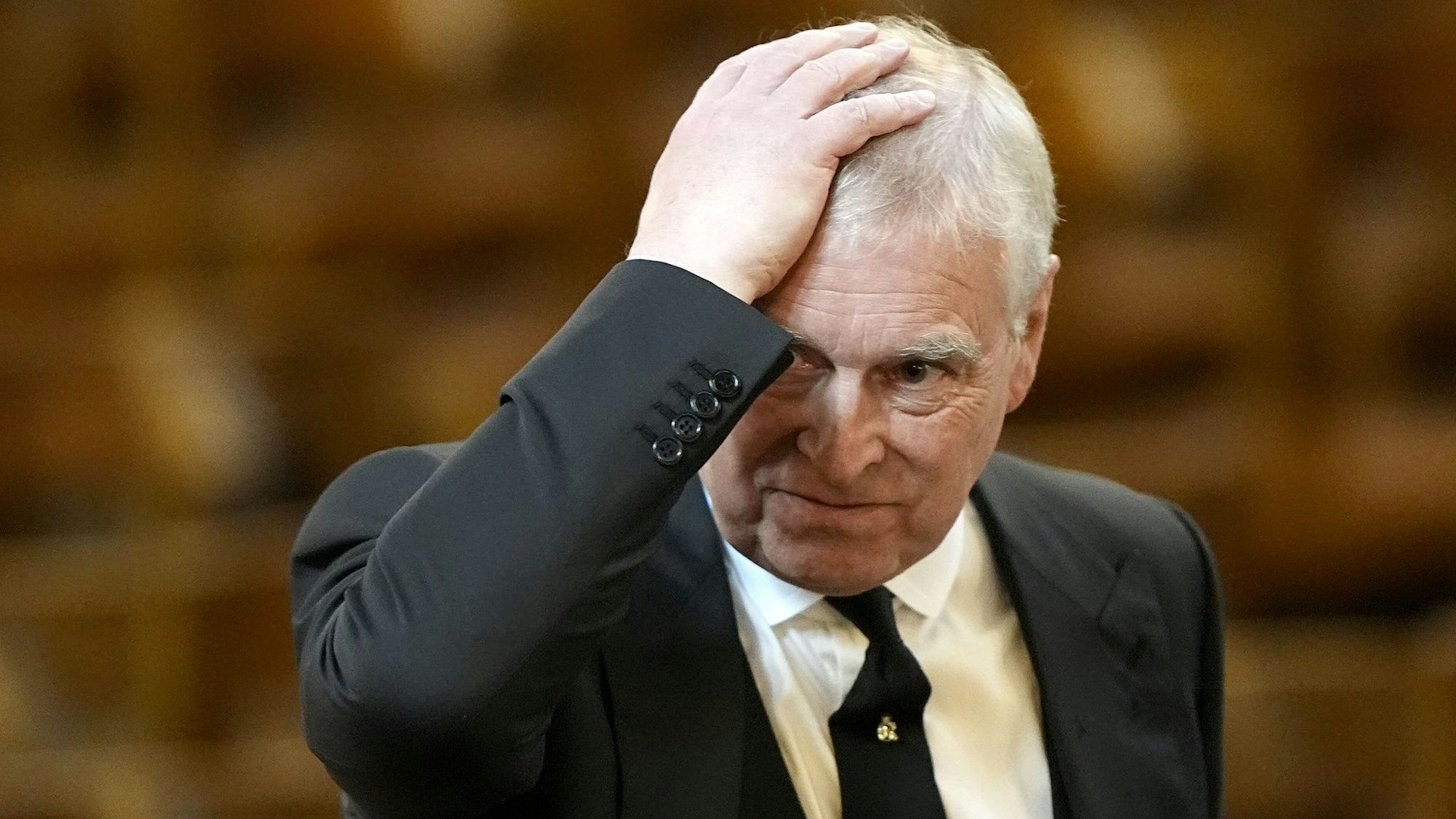 Prinz Andrew streicht sich über den Kopf.