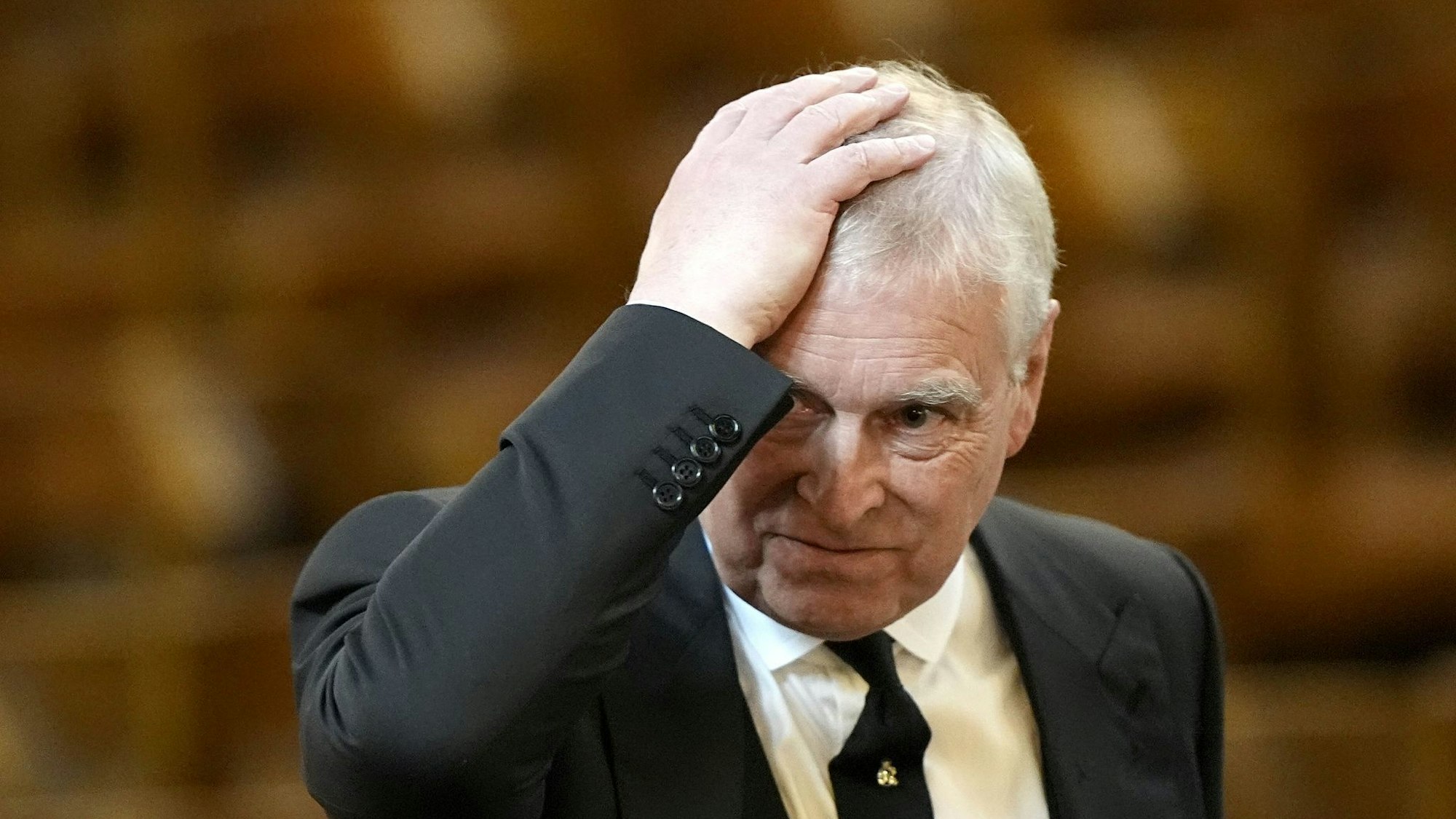 Prinz Andrew streicht sich über Kopf.