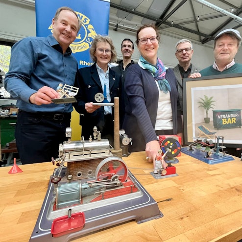 Menschen hinter einer Modell-Dampfmaschine