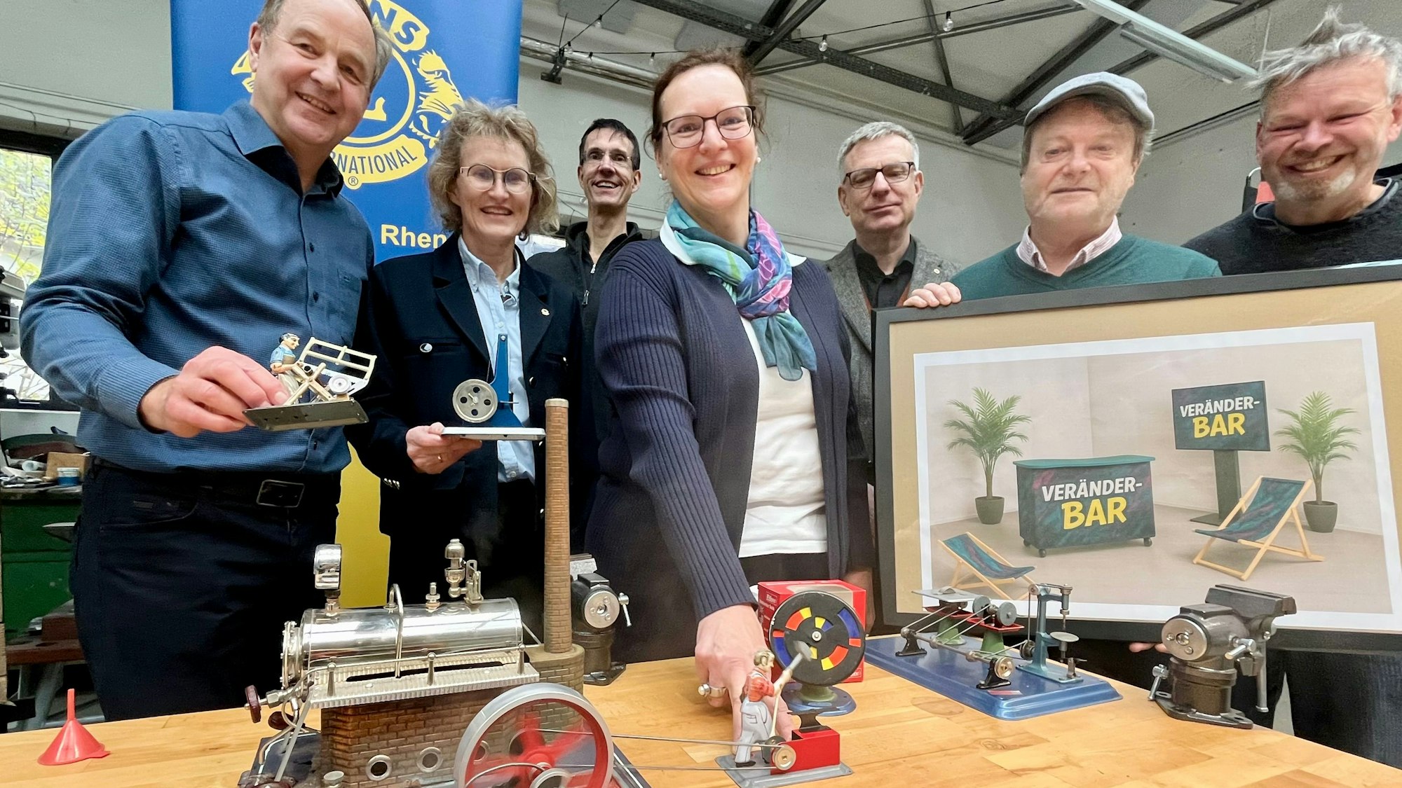 Menschen hinter einer Modell-Dampfmaschine