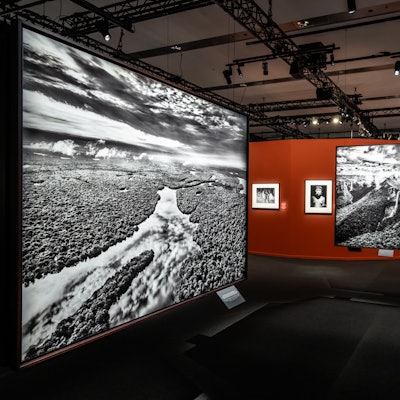 Das Foto von Sebastião Salgado im Vordergrund der Ausstellungsansicht zeigt dichte Wolken, dieschwere Regenfälle über dem Anavilhanas-Archipel verheißen, einer Kette von Flussinseln im Rio Negro, nördlich der Stadt Barcelos.