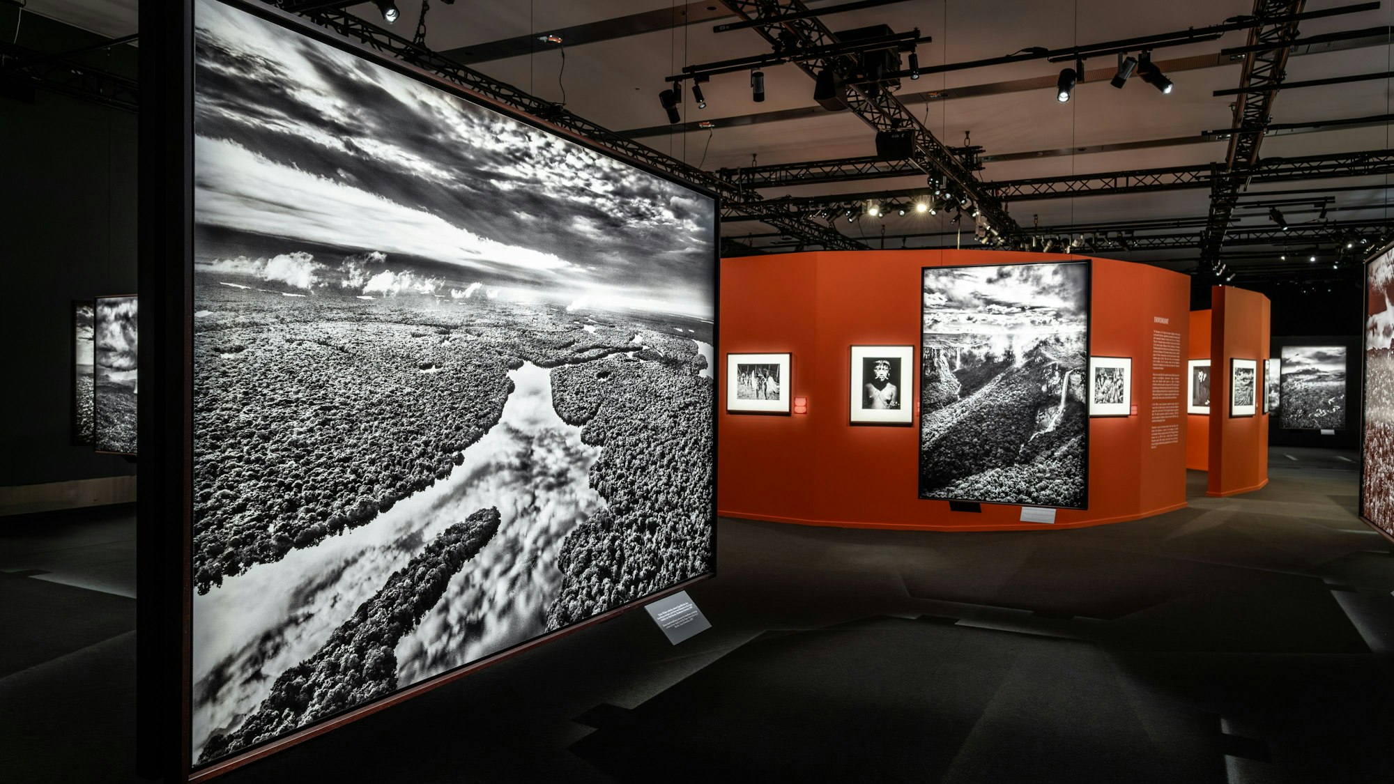 Das Foto von Sebastião Salgado im Vordergrund der Ausstellungsansicht zeigt dichte Wolken, dieschwere Regenfälle über dem Anavilhanas-Archipel verheißen, einer Kette von Flussinseln im Rio Negro, nördlich der Stadt Barcelos.