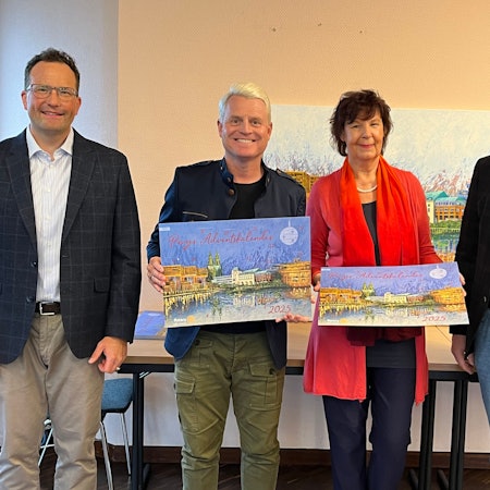 Drei Männer und eine Frau halten den aktuellen Adventskalender der Rotarier.