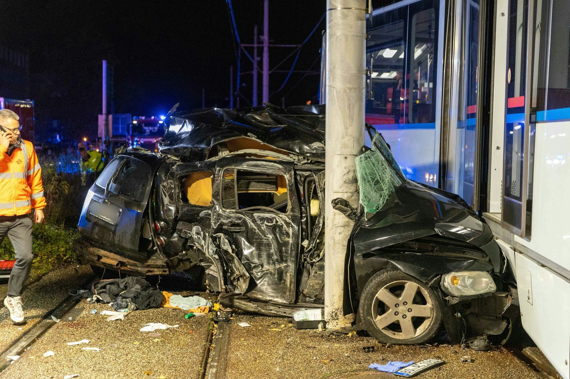 Das Auto wurde zwischen Betonmast und Straßenbahn eingeklemmt, die Aufräumarbeiten dauerten auch nachts noch an.
