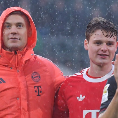 Jonas Urbig und Manuel Neuer feiern im Regen den Sieg in Möchengladbach.