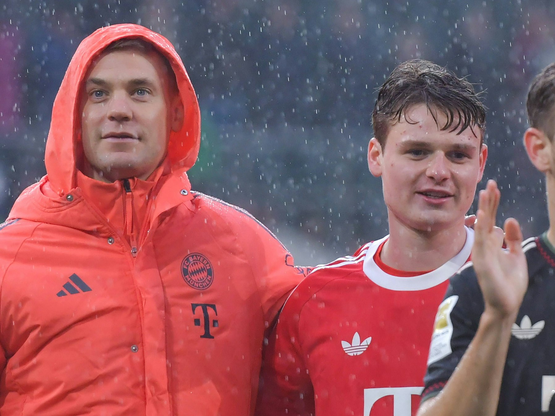 Jonas Urbig und Manuel Neuer feiern im Regen den Sieg in Möchengladbach.