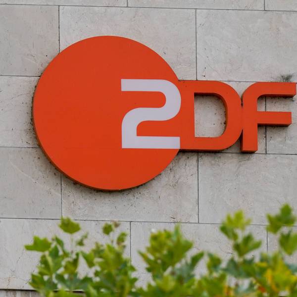 Orangefarbenes ZDF Logo an einer Steinwand, mit unscharfem Grün im Vordergrund