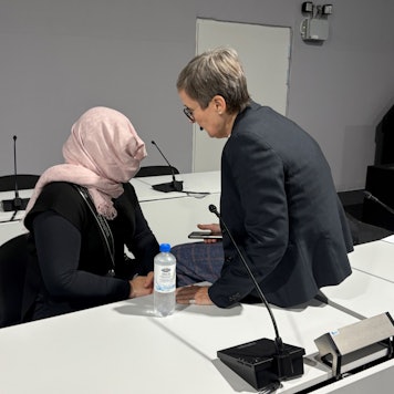 Die Angeklagte verdeckt im Amtsgericht Köln ihr Gesicht vor den anwesenden Pressefotografen. Rechts Verteidigerin Susanne Cziongalla.