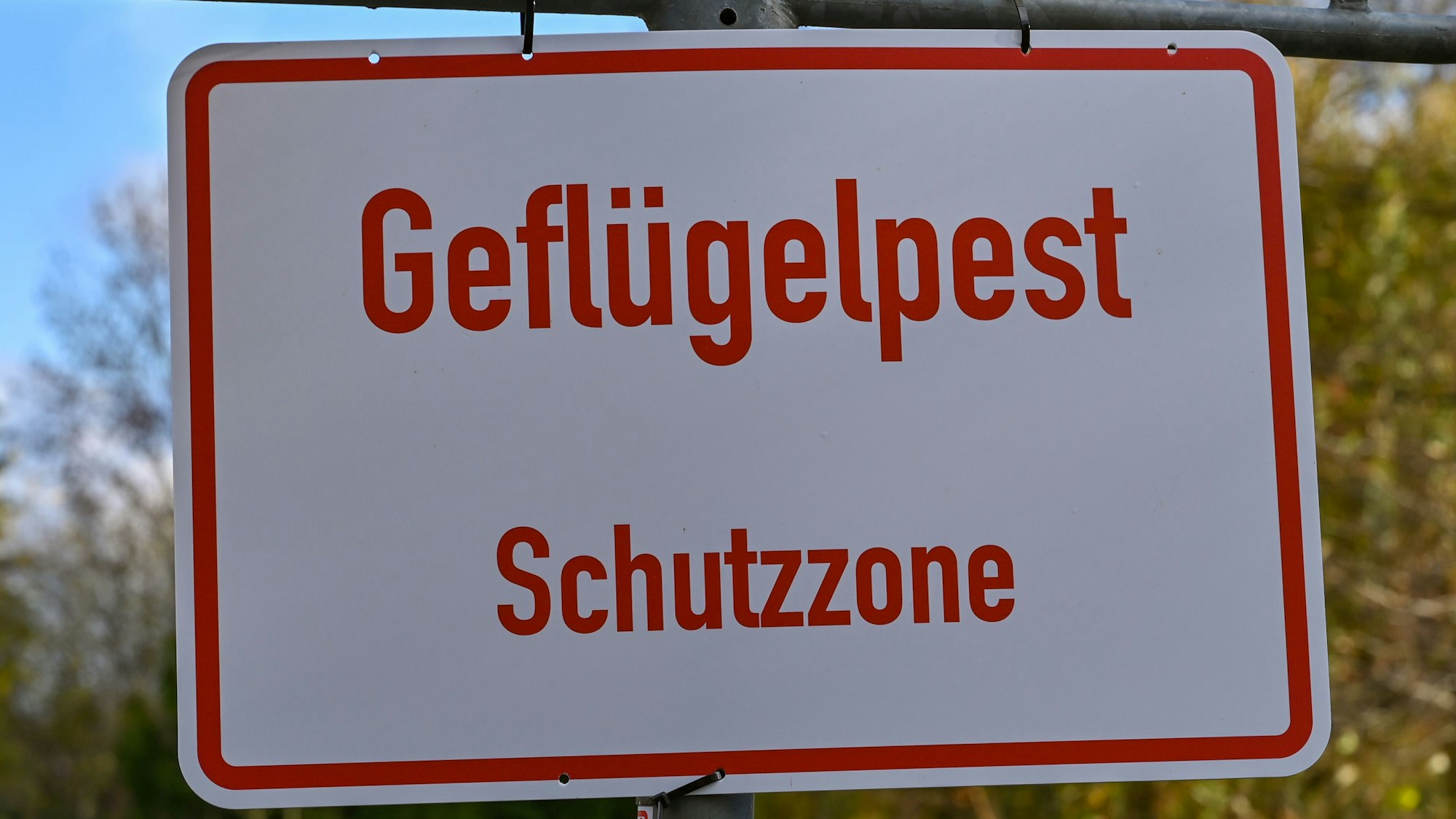 Ein Schild mit der Aufschrift „Geflügelpest Schutzzone“. (Archivfoto)