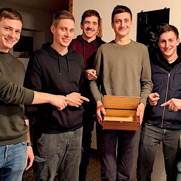 Sechs junge Männer zeigen auf die Sammelkiste, mit der sie durchs Dorf ziehen.