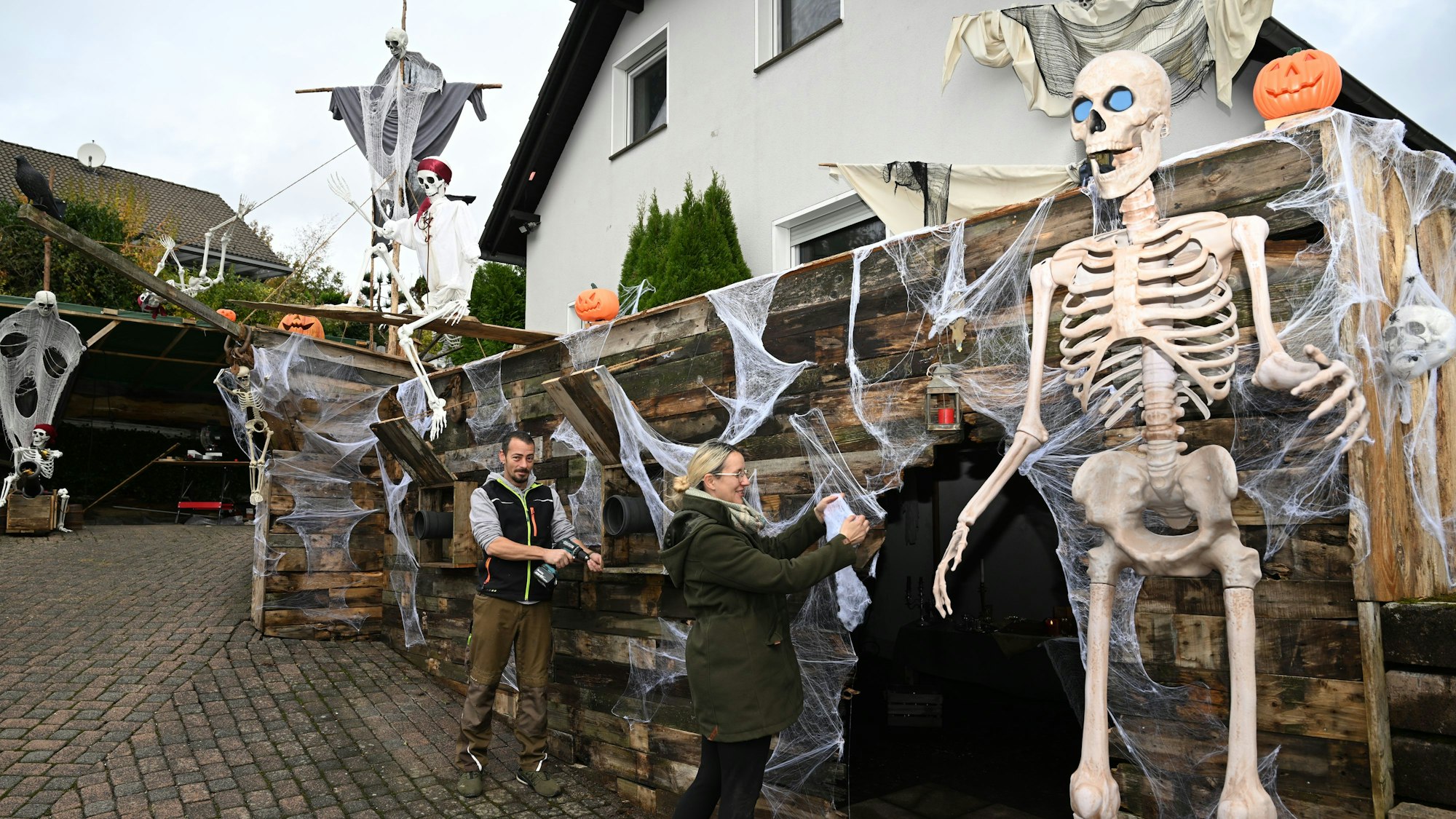 Zahlreiche Skelette finden sich auf dem zerschellten Piratenschiff. Miriam und Cornelius Weiss legen letzte Hand an ihre aufwendige Halloween-Szenerie.Lindlar. Das Gruselhaus von Miriam und Cornelius Weiss ist diesmal als Piratenschiff gestaltet.