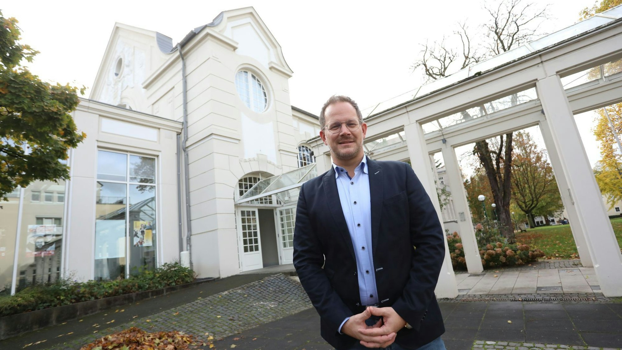 Ein Mann steht vor einem denkmalgeschützten Jugendstilgebäude.