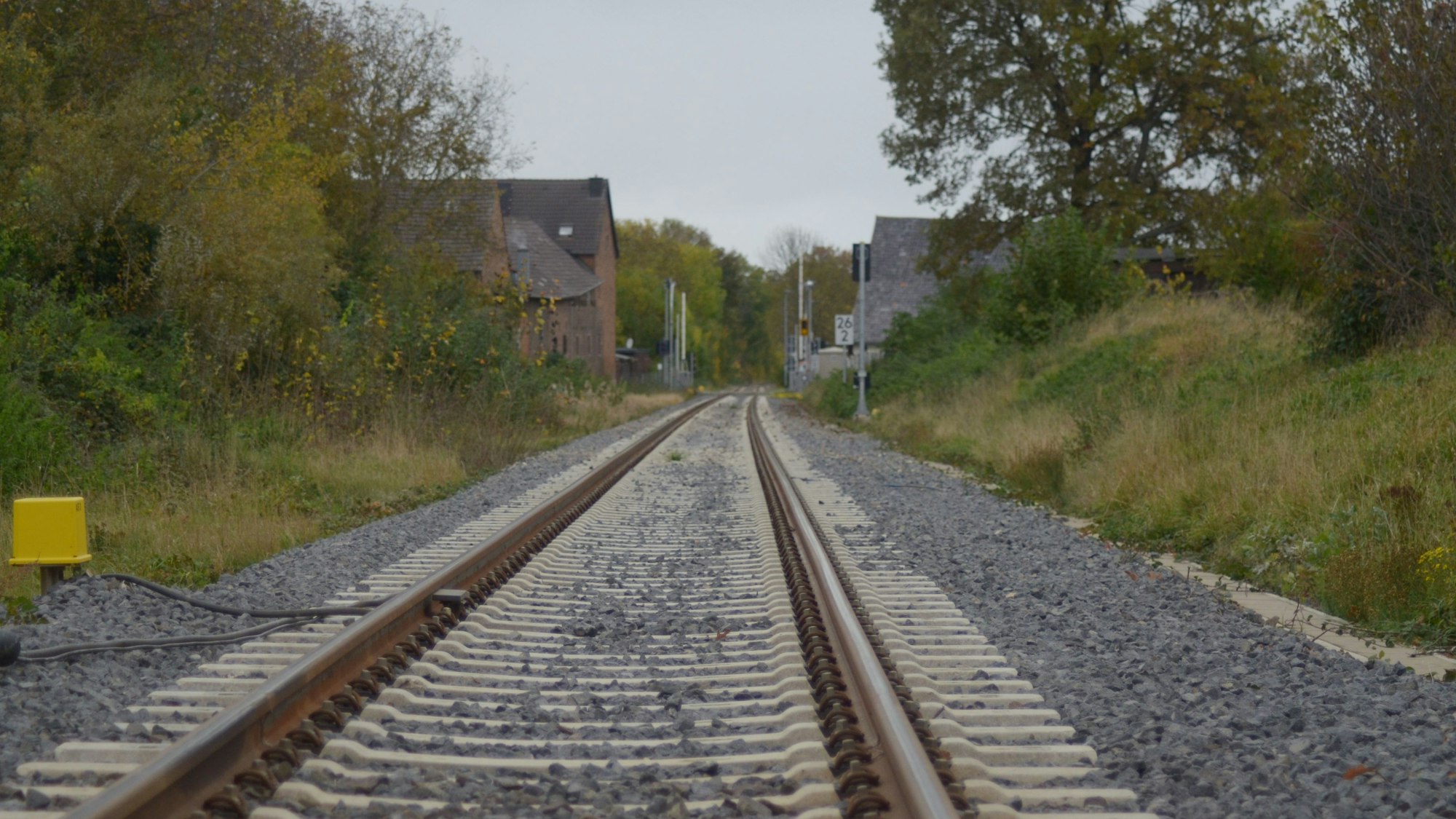 Das Bild zeigt ein Bahngleis, im Hintergrund Häuser und andere Gebäude.