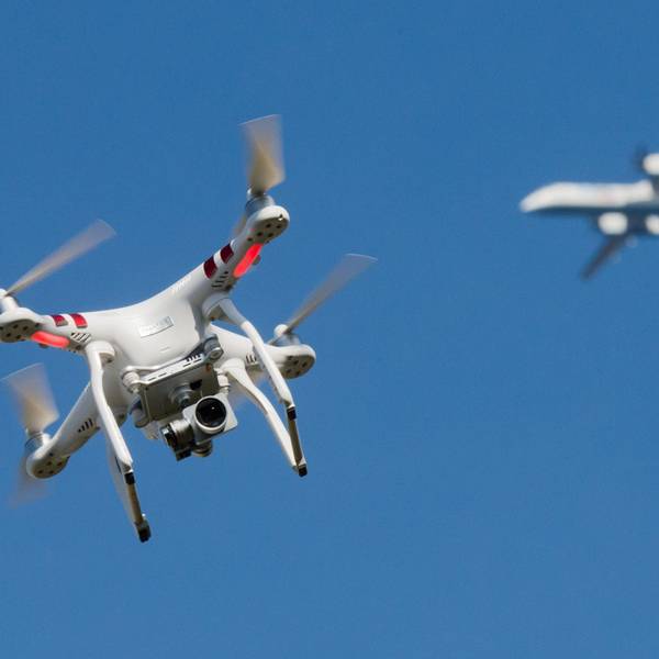 Eine private Drohne fliegt in einiger Entfernung von einem Flugzeug, das im Anflug auf den Flughafen Düsseldorf ist.