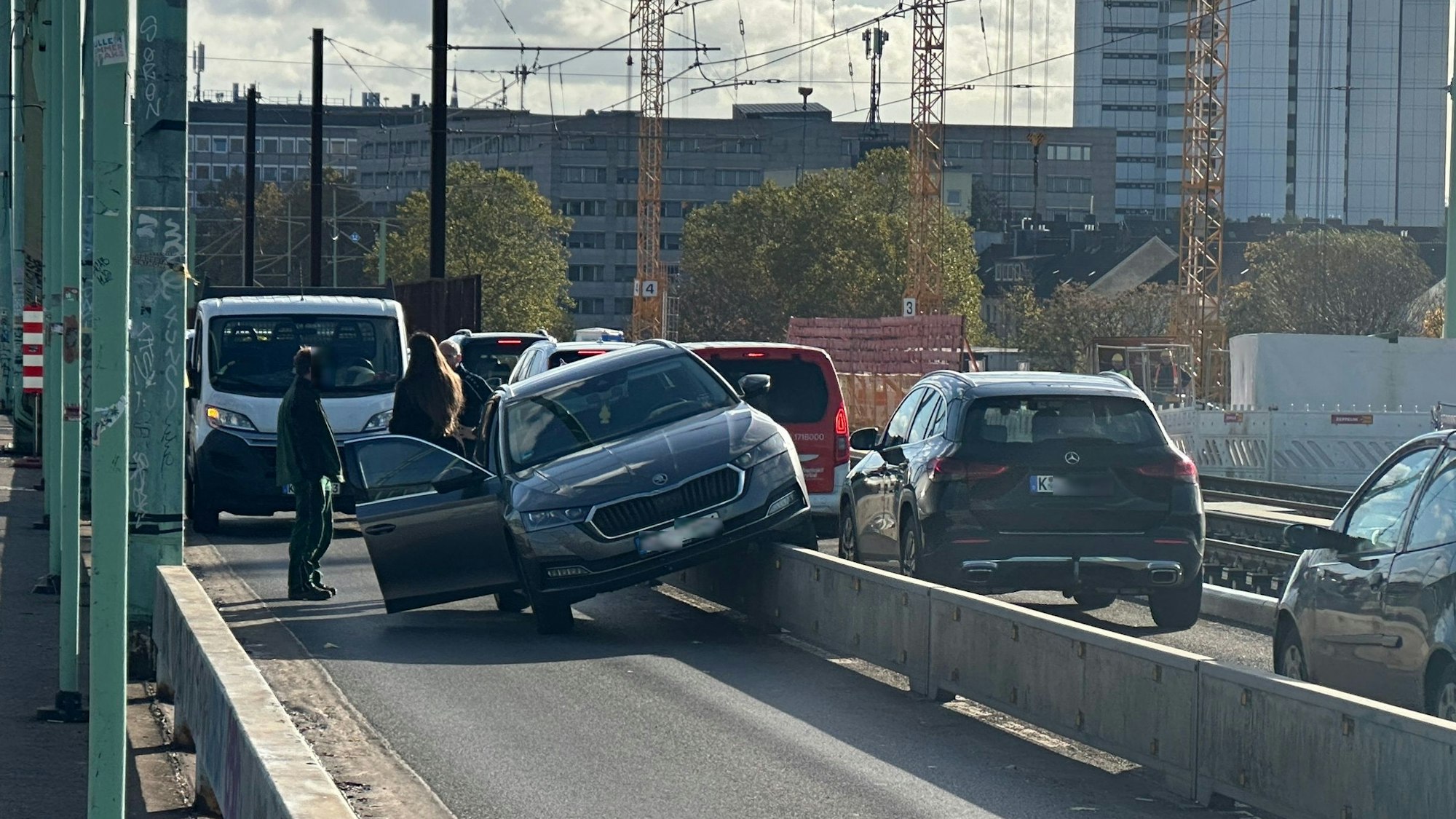 Ein Pkw hängt seitlich auf einer niedrigen Mauer zwischen zwei Fahrstreifen.