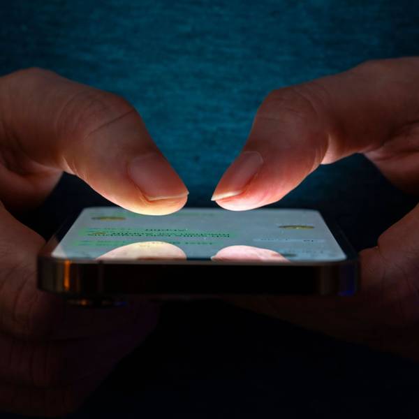 Eine Frau tippt auf einem Smartphone-Screen eine Nachricht.