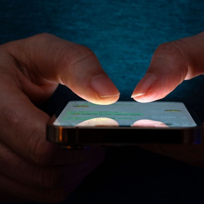 Eine Frau tippt auf einem Smartphone-Screen eine Nachricht.