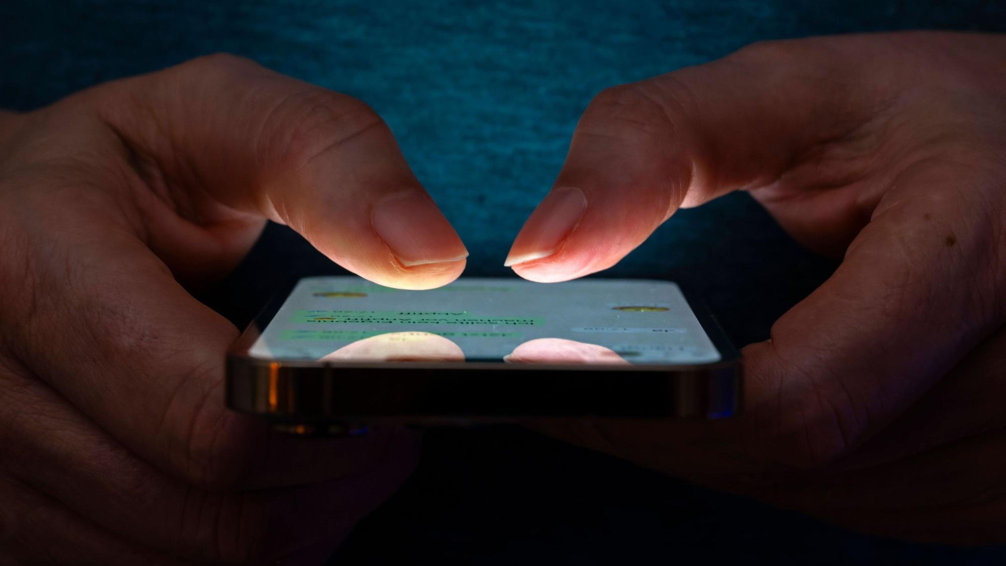 Eine Frau tippt auf einem Smartphone-Screen eine Nachricht.