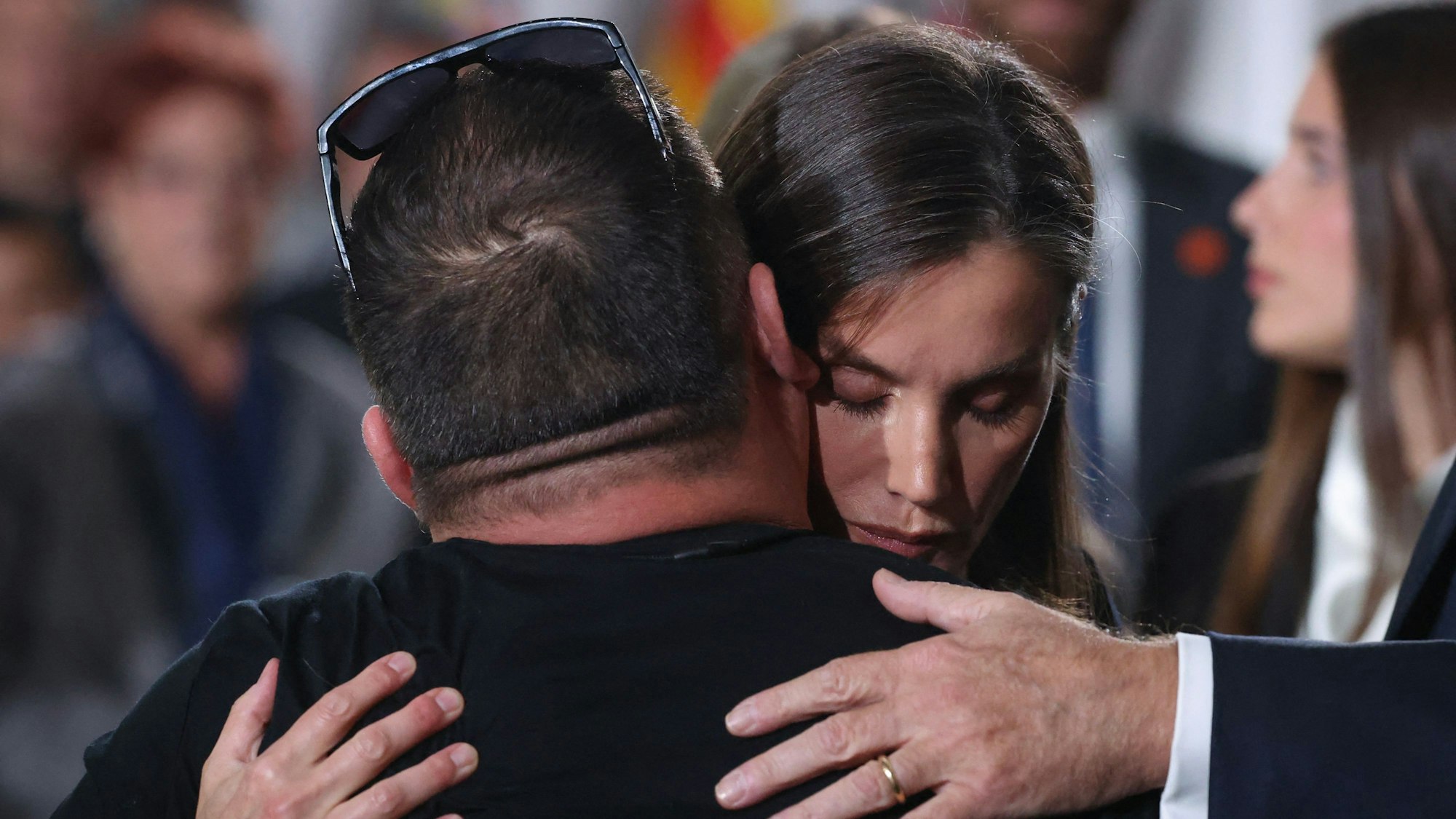 Königin Letizia umarmt Menschen.