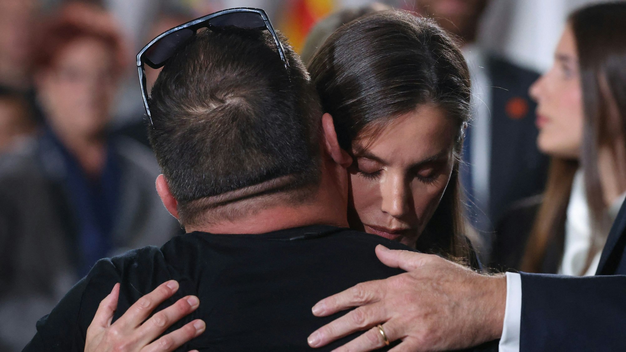 Königin Letizia umarmt Menschen.