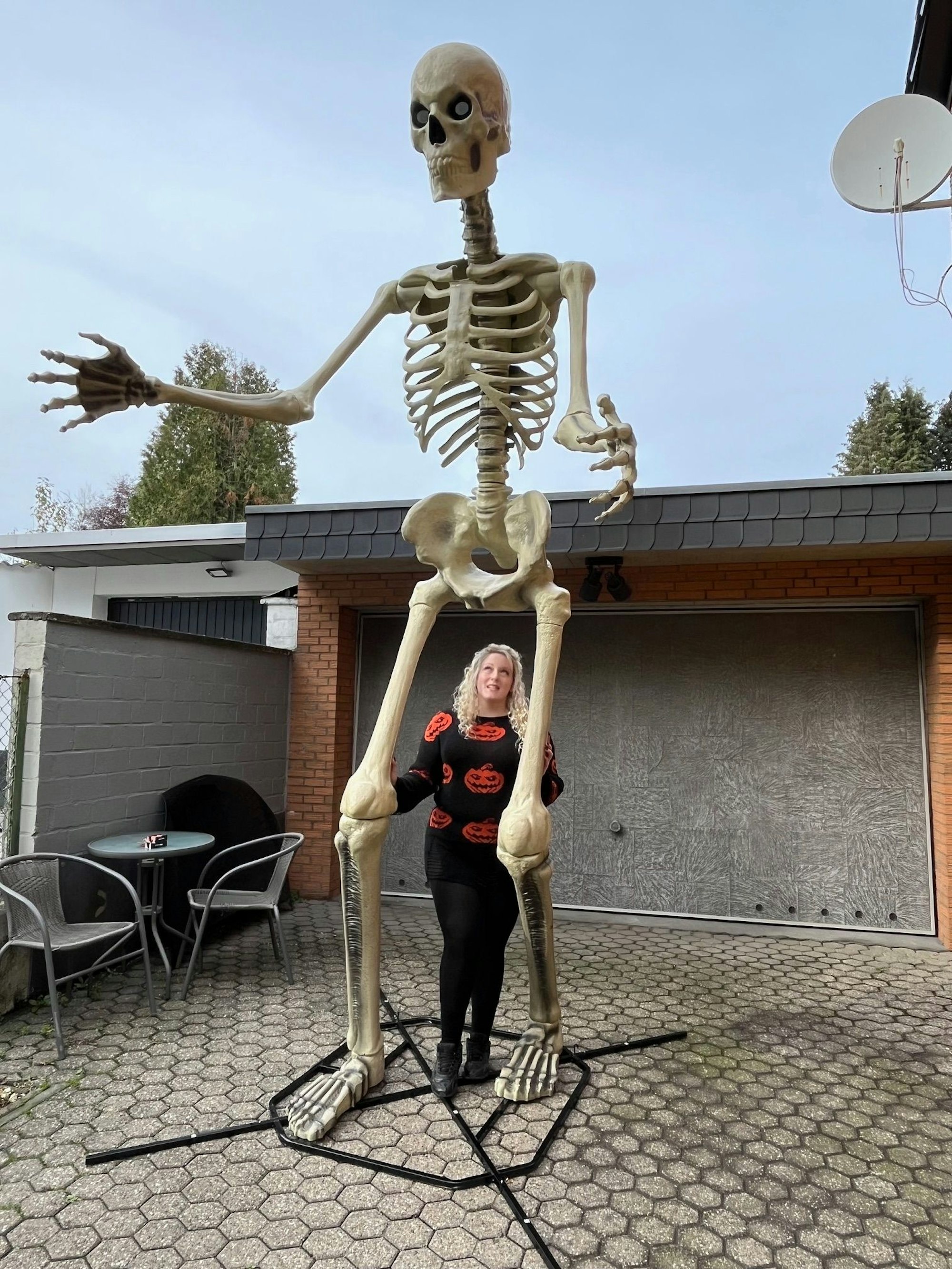 Das Foto zeigt eine Frau mit einem vier Meter hohen Skelett.