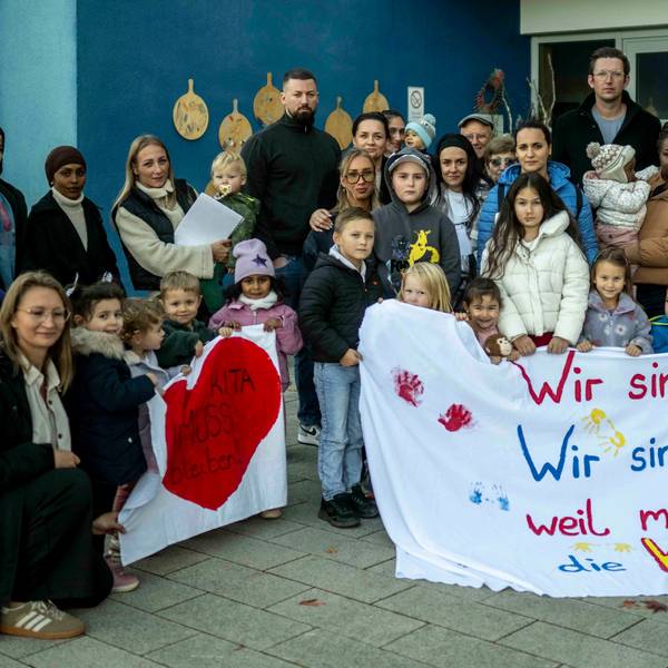 Das Bild zeigt Kinder und Erwachsene mit Protestbannern.
