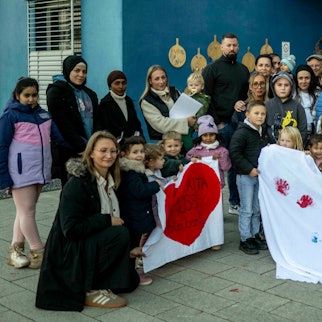 Das Bild zeigt Kinder und Erwachsene mit Protestbannern.