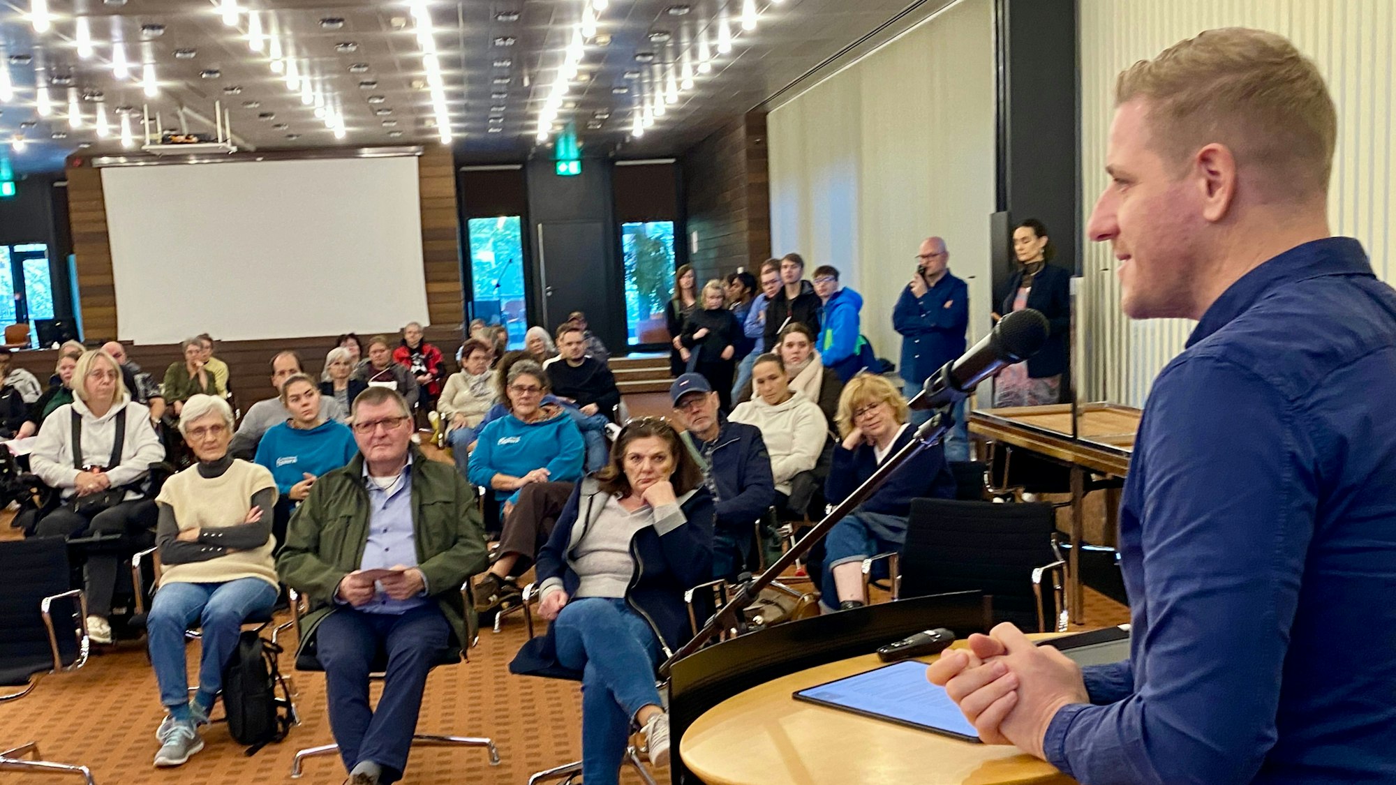 Landrat Markus Ramers steht am Rednerpult, vor ihm sitzen Menschen und hören ihm zu.