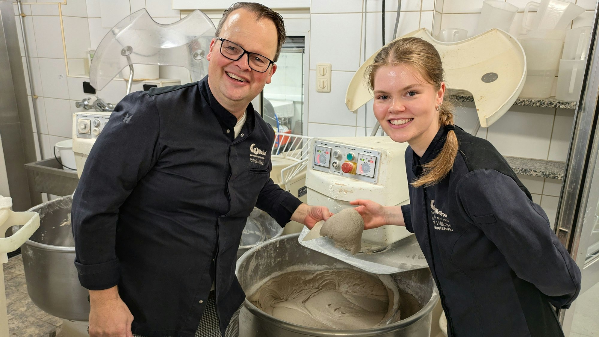 Ein Mann und eine Frau stehen an einem Bottich mit Sauerteig.